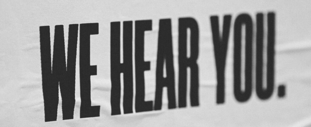 la scritta "we hear you." è stampata su un foglio bianco