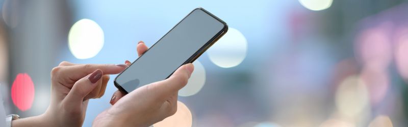 Una donna tiene in mano uno smartphone spento
